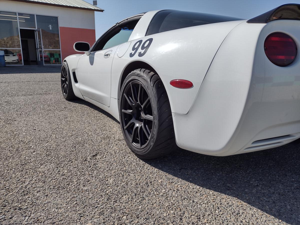 White C5 Corvette at the track posing with Apex SM10 ET57 wheels and caddilac brembos underneath