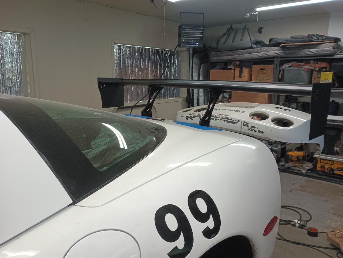 A C5 Corvette parked in a shop with a Shred Jesse DIY Wing Powder Coated black attached on the back