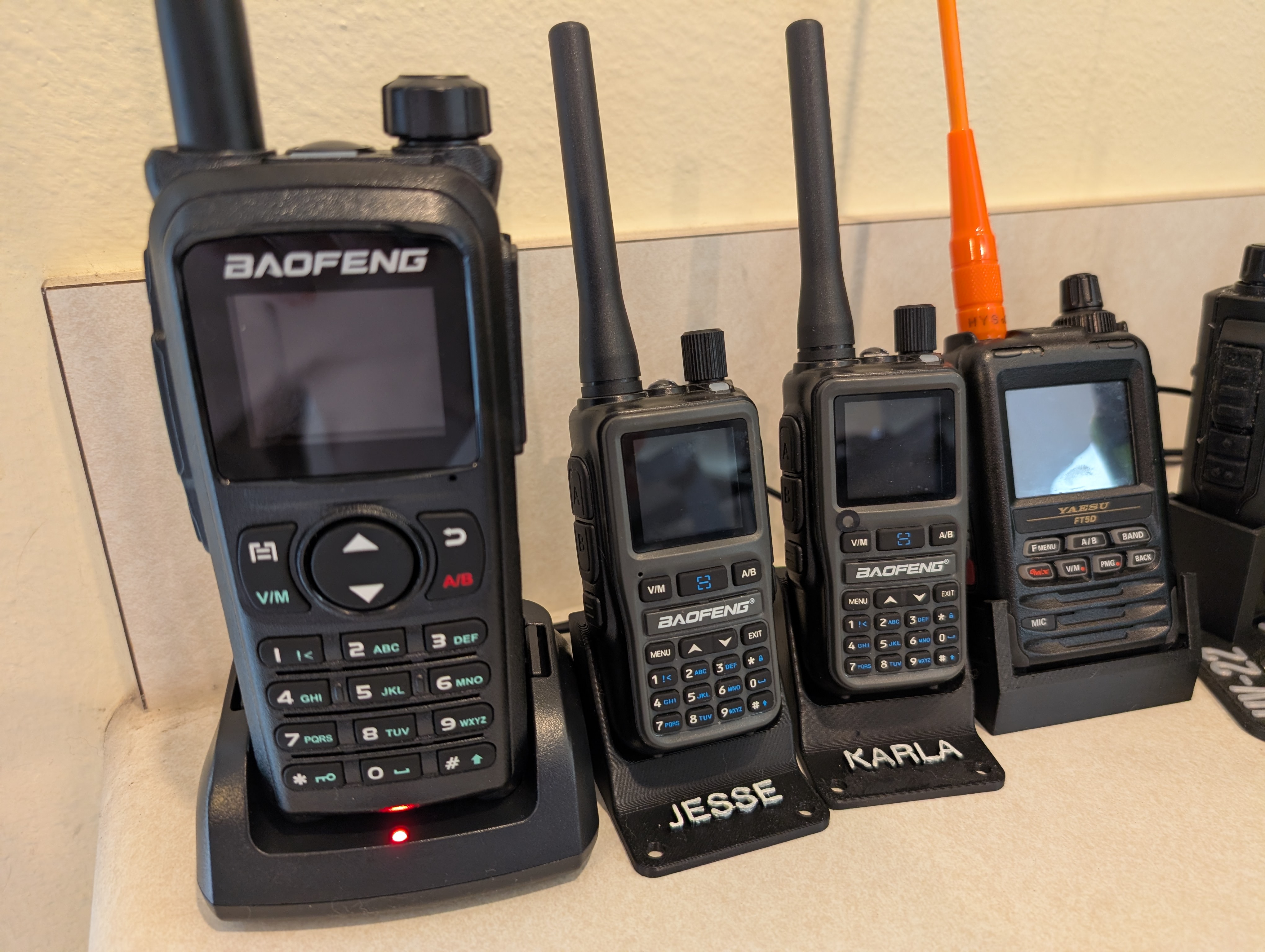 A Baofeng UV-28+ pictured on the left, next to 2x Baofeng UV-5R mini's and a Yaesu FT5DR