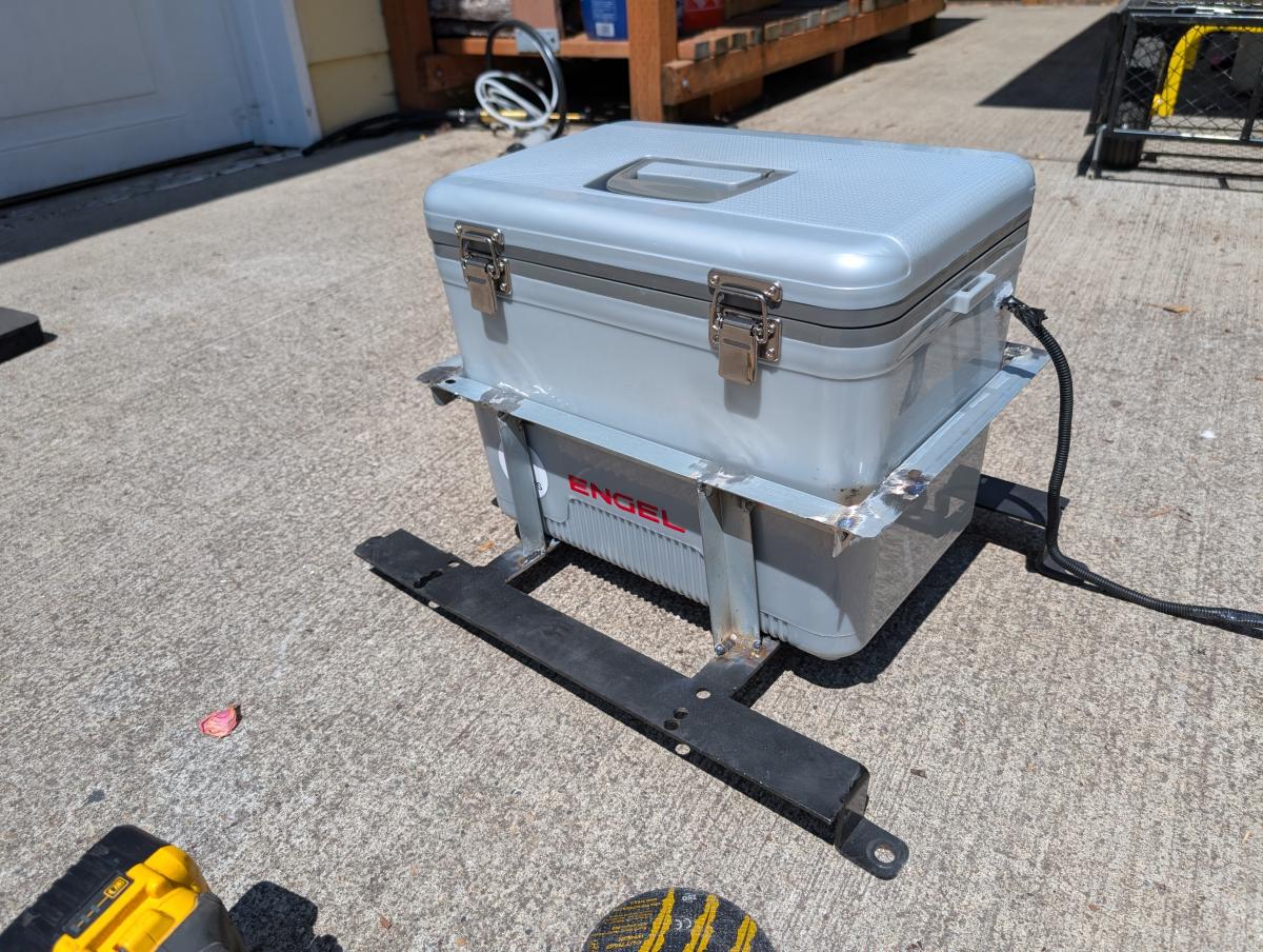 My DIY cool shirt cooler sitting in a custom frame to hold it in place while driving.