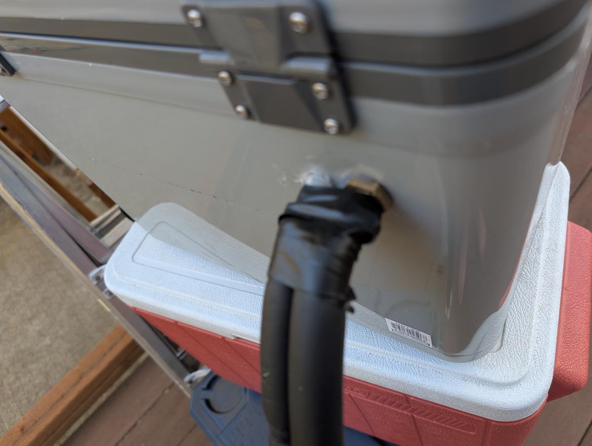 A picture showing how we routed the hoses through the cooler wall of our DIY cool shirt cooler.
