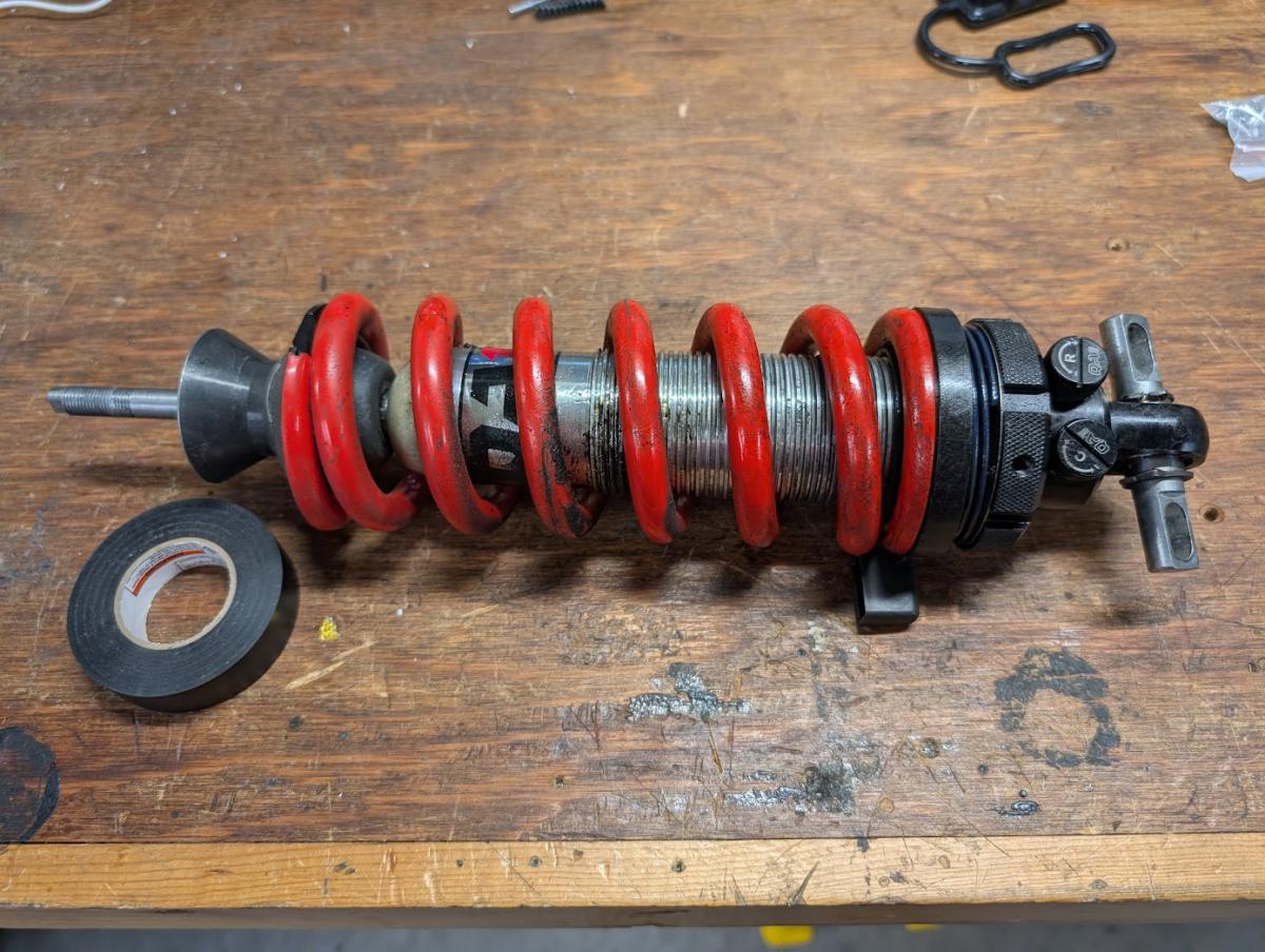 A compressed QA1 coil over covered in oil demonstrating that it has blown.