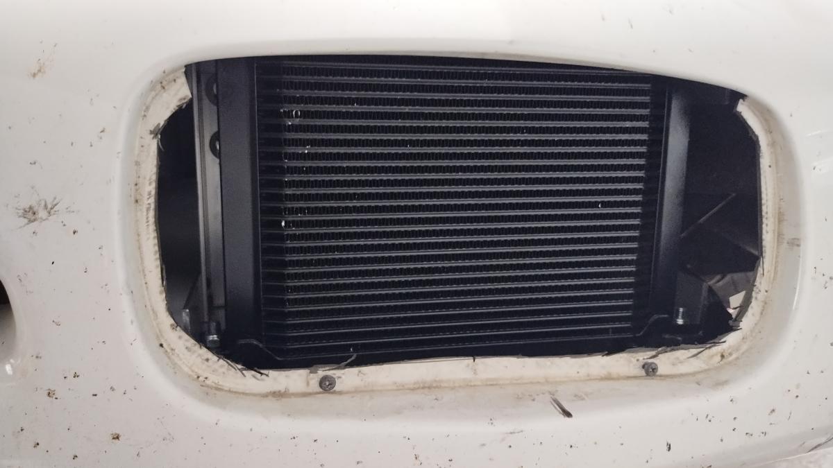 A closeup of the 25 row oil cooler through the license plate opening on the front of a 1999 C5 Corvette. The trimming around the edge is not the greatest, but it gets the job done!