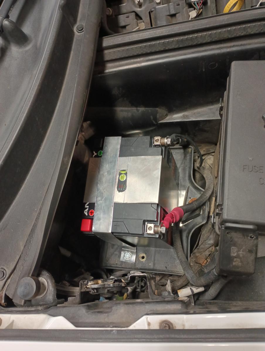 Antigravy battery mounted in Jesse's c5 Corvette, fully mounted in place with DIY bent aluminum over the battery.