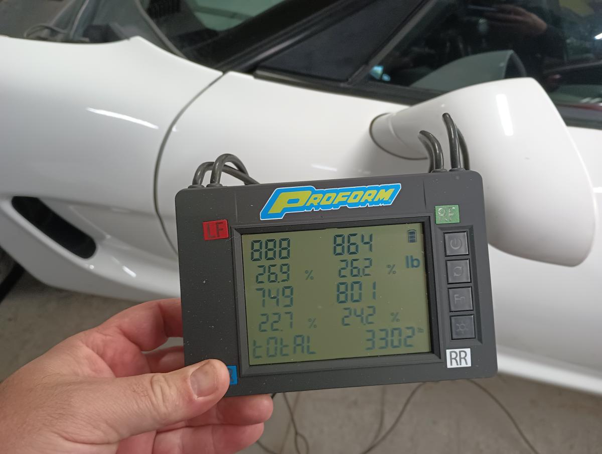 C5 Corvette being corner weighed on Proform scales. Showing 888lbs front left, 864lbs front right, 749lbs back left, 801lbs back right. Total weight is 3302lbs.