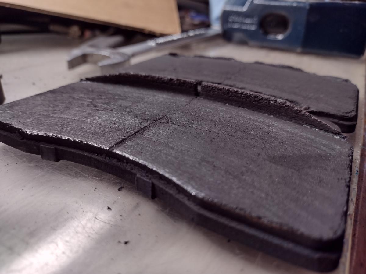 A set of worn powerstop trackday brake pads, with a slight overhang from the C5 Caddillac Brembo brake setup.