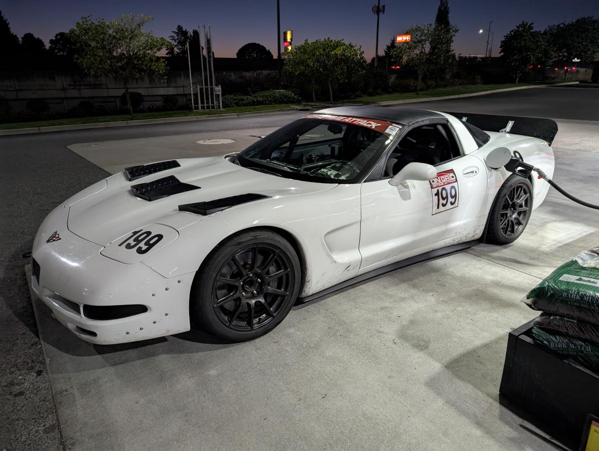 White C5 Corvette getting gas, with the new custom DIY spoiler mounted to the Corvette.