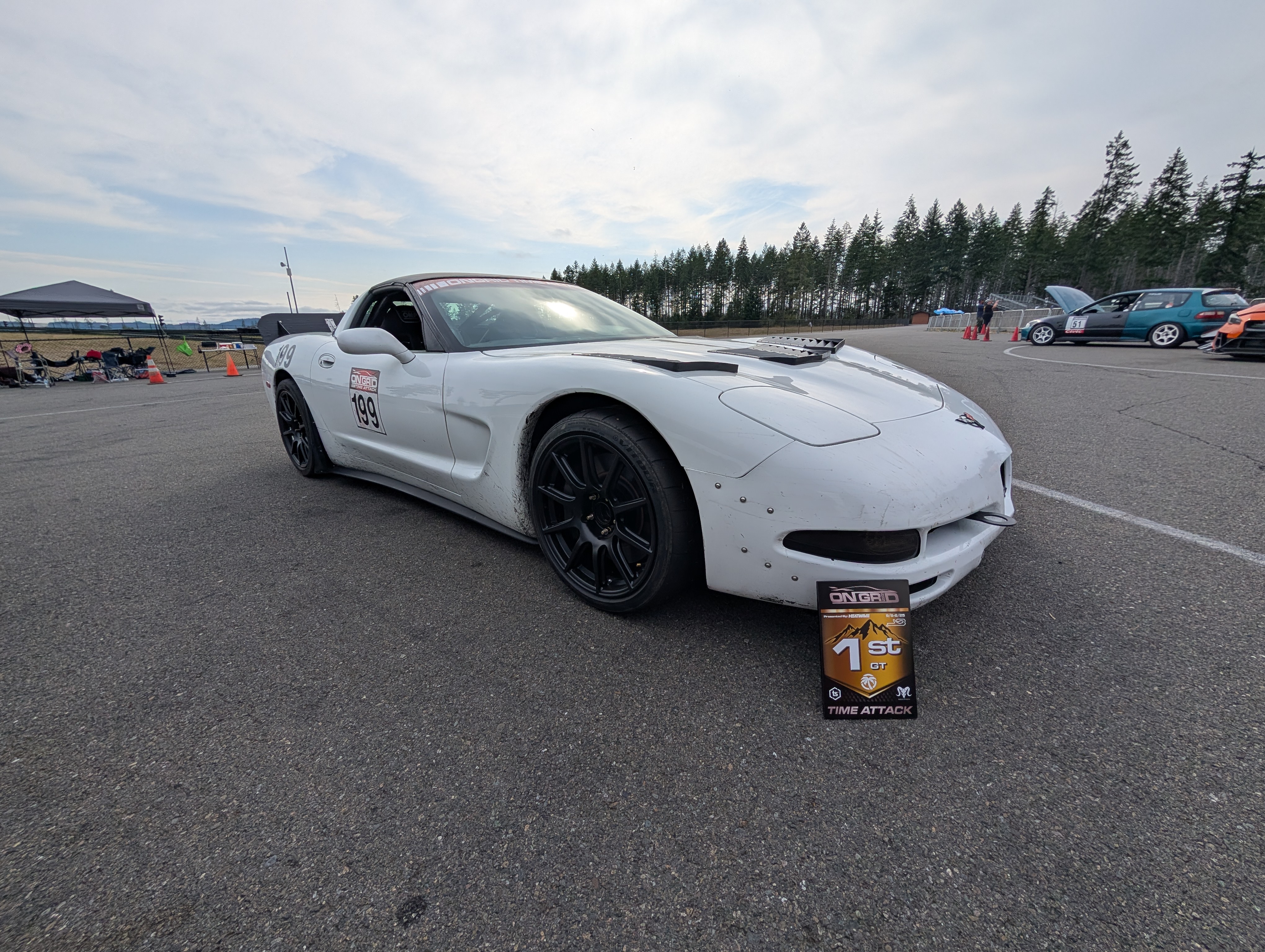 Shred Jesse's white C5 Corvette as viewed from the front with his 1st place plaque leaned up against the car.