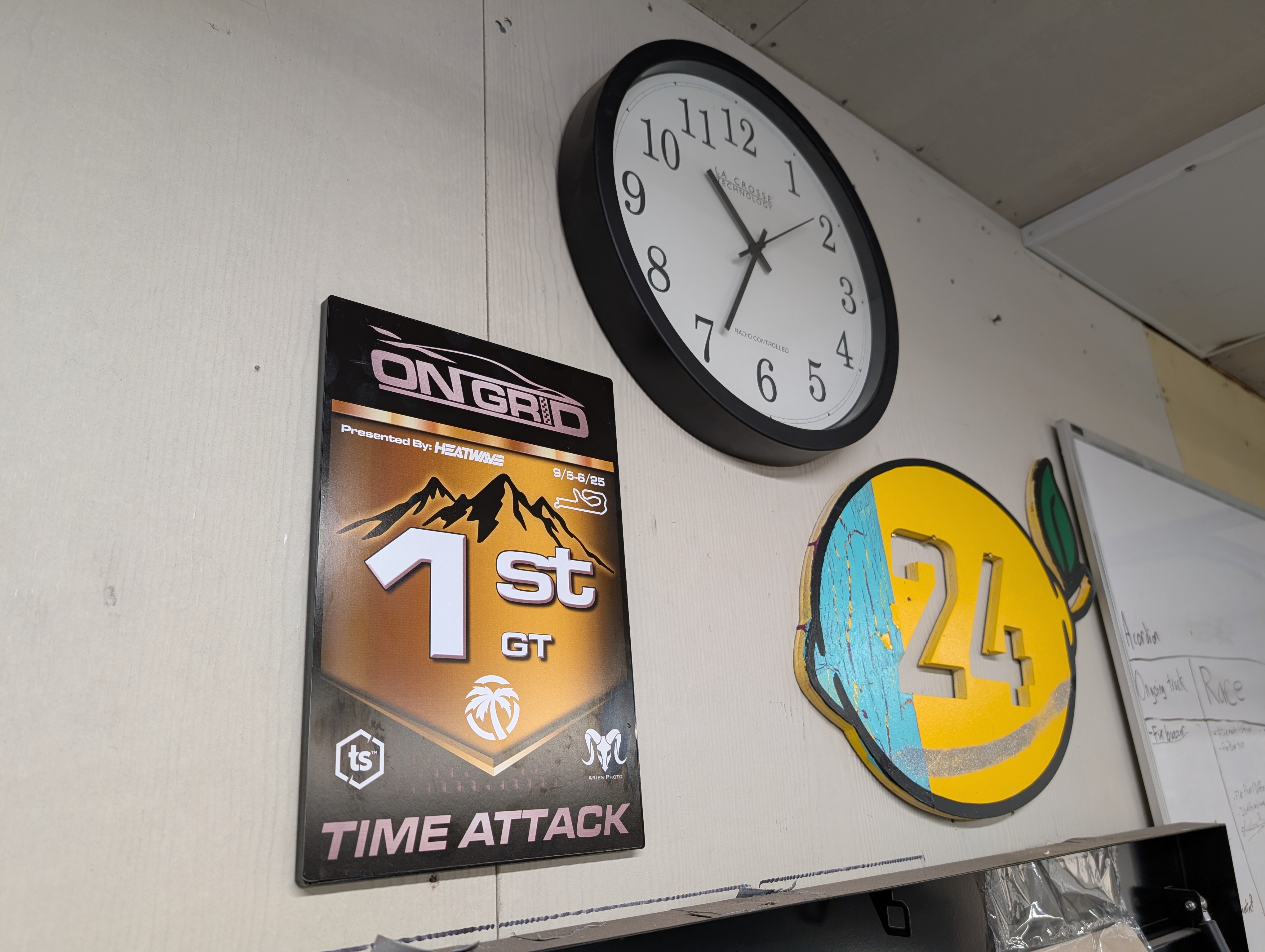 Shred Jesse's Shop Wall, sporting his first place plaque from OnGrid, next to his teams first place plaque from 24 hours of lemons.