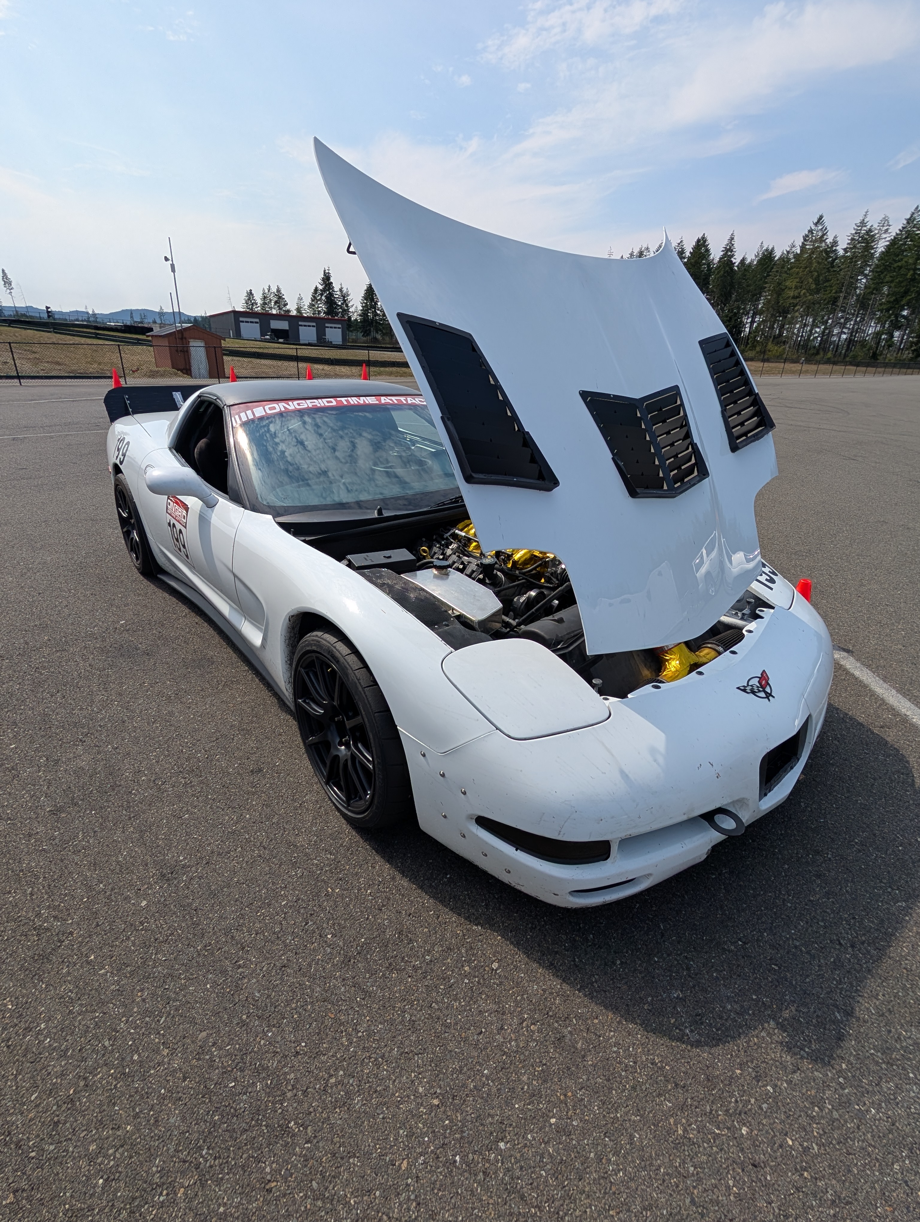 A front view of Shred Jesse's white C5 Corvette with the hood popped, in full OnGrid GT class configuration.