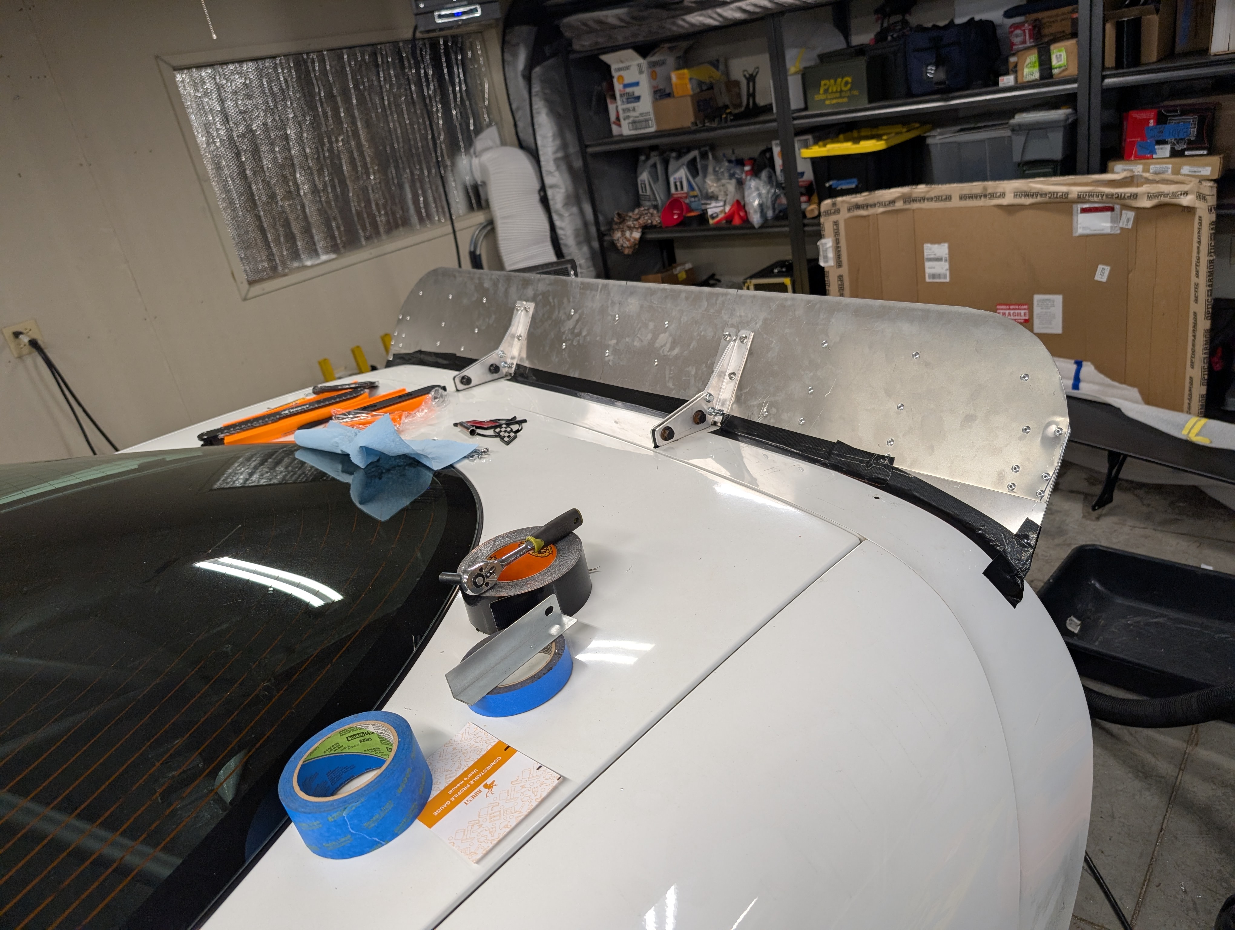 The rear of a c5 Corvette showing the original version of the bare aluminum spoiler. It is only supported in the middle by brackets from chassis mount up.