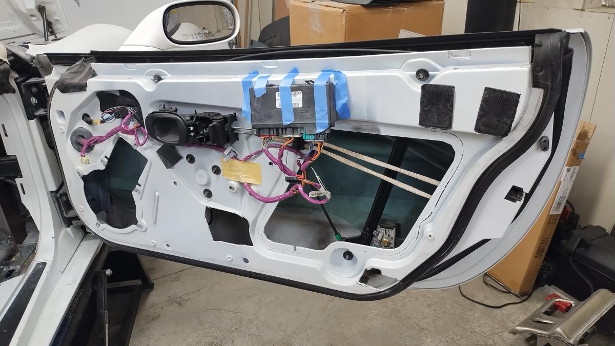 A gutted and open C5 Corvette passenger door, with the previosuly two highlighted areas cut out for where they impacted the Trackspec C5 corvette rollcage