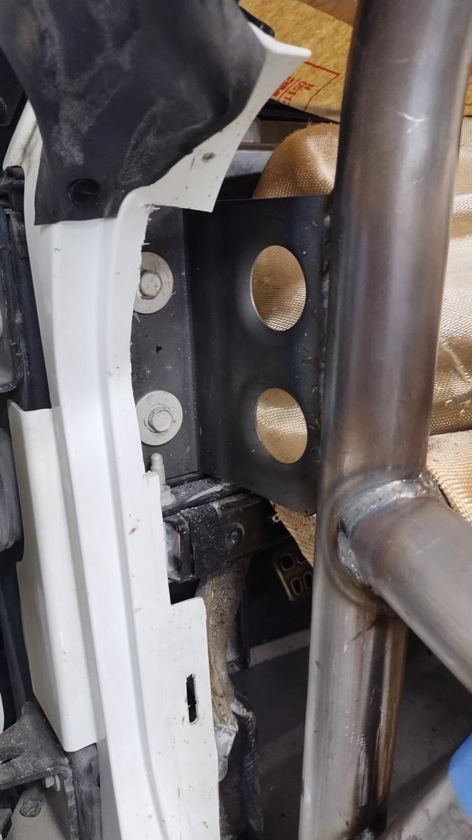 A custom L shaped bracket on the passenger side attaching the front windshield support of the C5 Corvette Trackspec Rollcage to the chassis of the Corvette