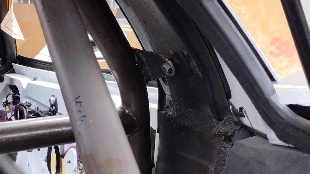 A small bracket attaching the main hoop of the C5 Corvette Trackspec Rollcage to the upper seat belt location on the factory halo