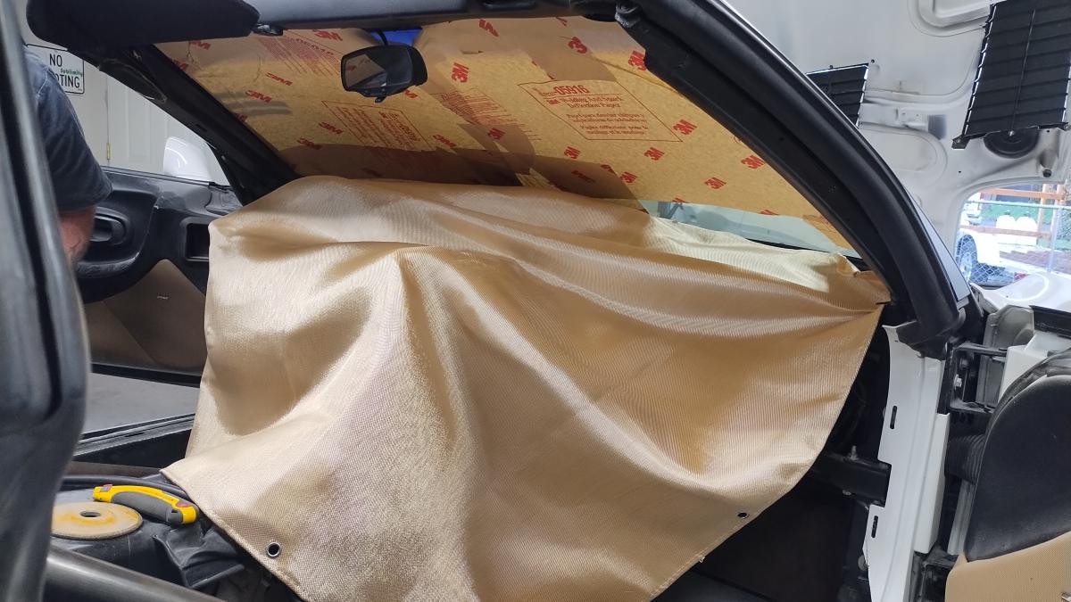 A welding blanket splayed out over the dashboard with anti spatter welding paper on the windshield to ensure nothing on the C5 Corvette is damaged during installation of the Trackspec rollcage.