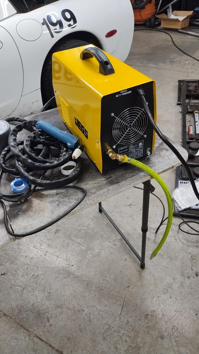 A jegs Plasma cutter on a table in front of the C5 Corvette. In my opinion this is essential for installing the Trackspec Roll cage and DIY fabrication in general.